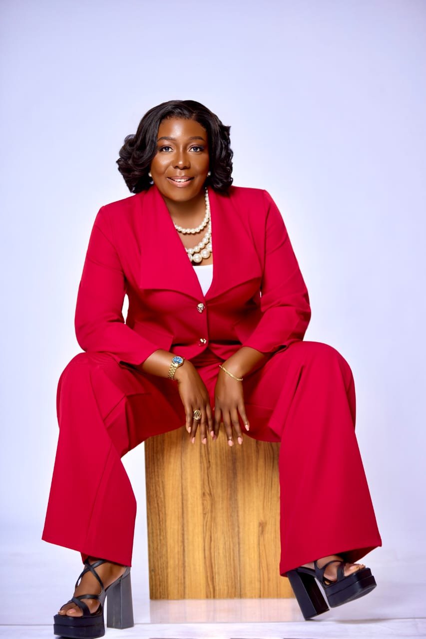 Kesewaa Kessy seated in a red suit